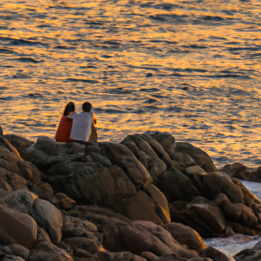 זוג נהנה משקיעה רומנטית על החופים הסלעיים של איקריה